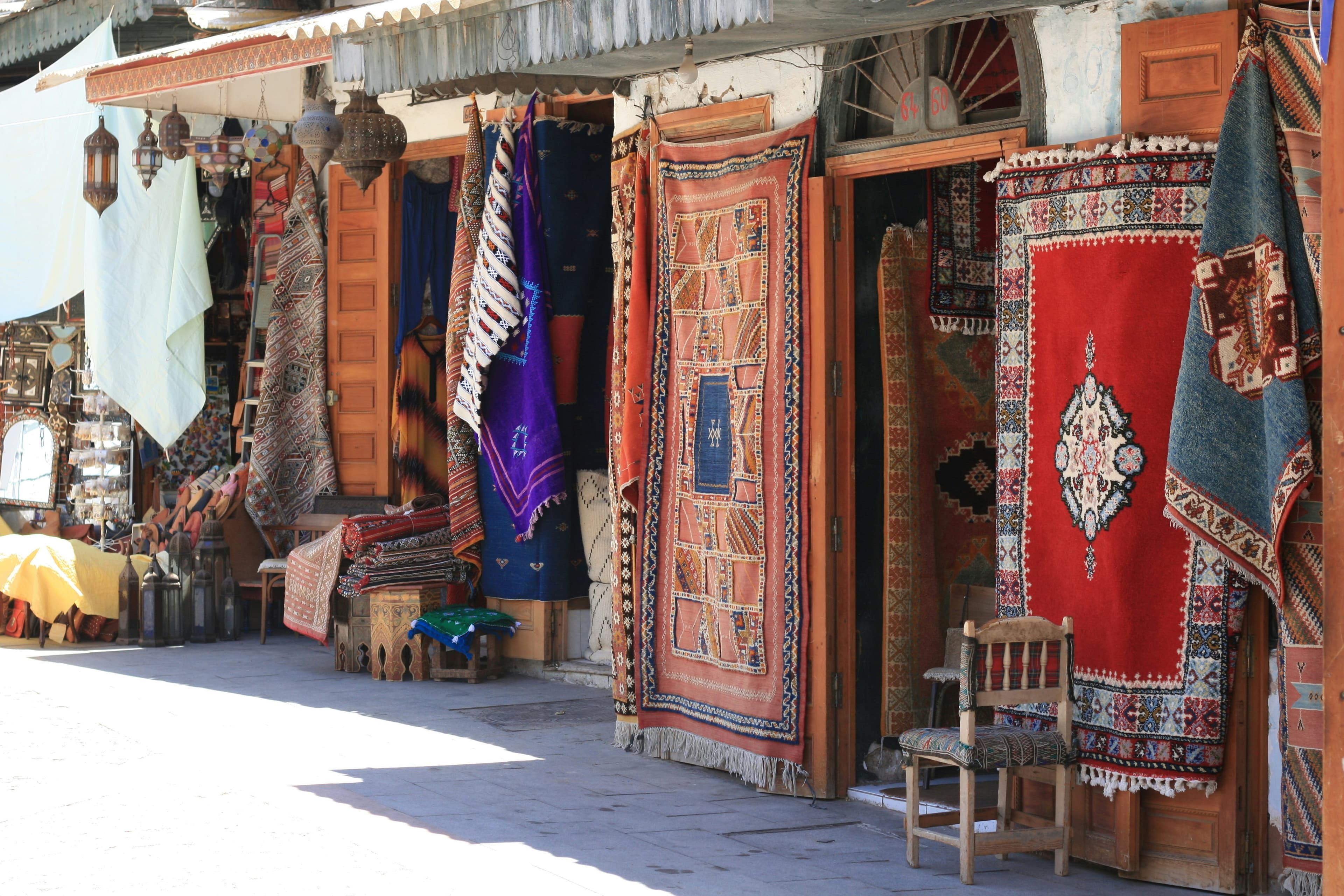 Oriental rug dealer with rugs hanging in a bazaar